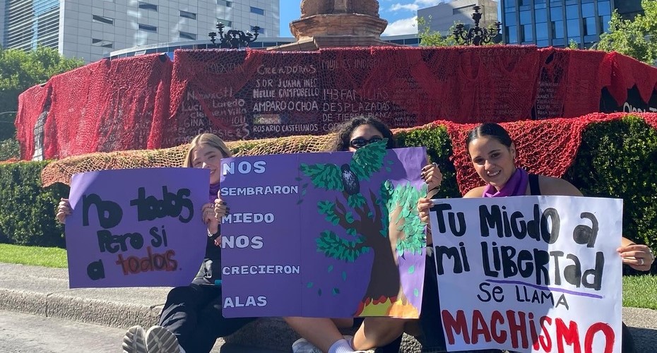 Foto de 3 mujeres sosteniendo carteles en la marcha 